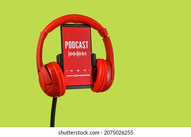 Modern headphones and mobile phone with podcast playlist on screen against color background