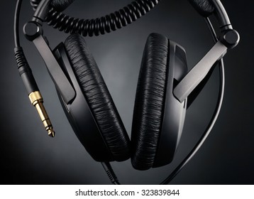 Modern headphones over black background - Shutterstock ID 323839844