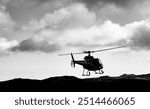 Modern helicopter landing in a remote volcanic landscape in Iceland. Helicopter in front of a dramatic cloudy sky with rotating rotor, landing skids. Black and white shot with strong contrasts.