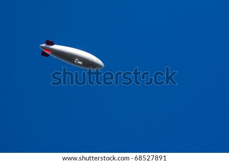 Modern helium filled zeppelin aircraft floating in perfectly blue sky.
