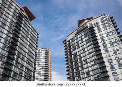Modern highrise building or tall residential towers with blue sky. Group of tall glass buildings. Empty homes tax, speculation tax or gentrification concept. Vancouver, BC, Canada. Selective focus. - Shutterstock ID 2277937971