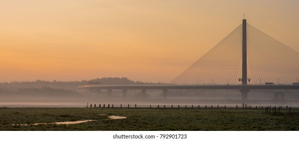 Modern Highway Road Bridge In Orange 
Foggy Winter Sunrise, Warrington, Cheshire, England