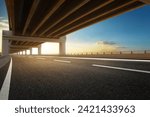 Modern highway road under the overpass with sunset sky.