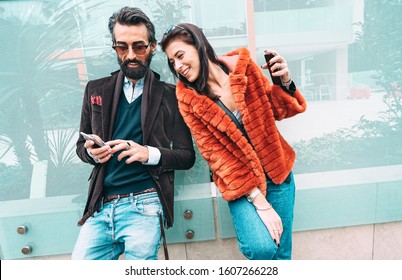 Modern Hipster Couple Having Fun Using Mobile Smart Phone Outside - Social Interaction Concept With Friends Sharing Digital Content On Social Media Networks - Millenial Generation Dating Online