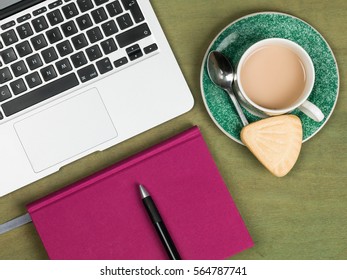 Modern Home Based Workstation With Laptop Computer Cup Of Tea And A Notebook