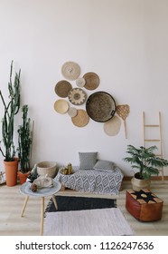Modern home interior design. Boho style, exotic home interior design with decorative straw plates on the wall