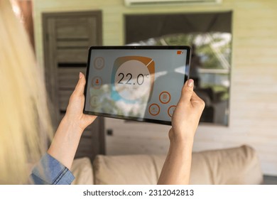 Modern home smart automation app on tablet display in woman hands. - Shutterstock ID 2312042813