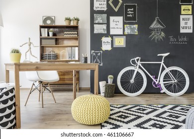 Modern Home Space With Chalkboard Wall, Bike, Pouffe, Pattern Carpet, Desk And Chair