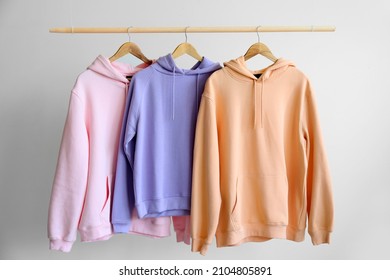 Modern Hoodies Hanging On Light Wall