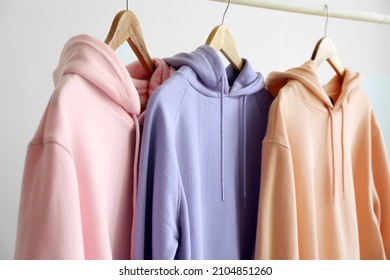 Modern Hoodies Hanging On Light Wall