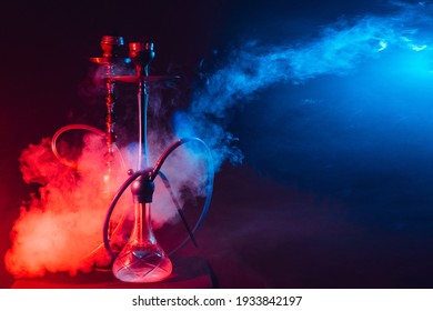 Modern Hookah, Shisha On A Smoky Black Background With Neon Lighting And Smoke. Place For Your Text