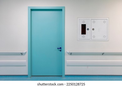 Modern hospital corridor with blue doors and flooring