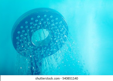 Modern Hot Shower With Stream Of Water Close Up On A Blue Background