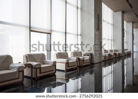 Modern hotel lobby with white sofas and polished marble flooring under natural light