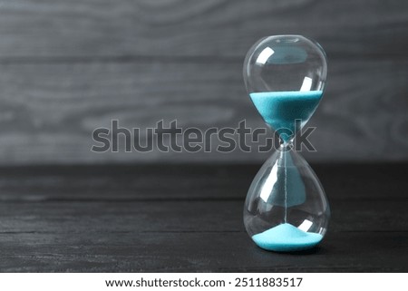 Modern hourglass on wooden background. Hourglass time concept for business deadline, urgency and outcome of time