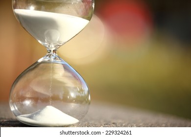 Modern Hourglass -- sand trickling through the bulbs of a crystal sand glass. every second counts. symbol of time. Christmas countdown.