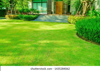 Modern House With Beautiful Landscaped Front Yard, Garden With Fresh Green Grass Both Shrub And Flower Front Lawn Background, Garden Landscape Design Fresh Grass Smooth Lawn With Curve Form Bush.