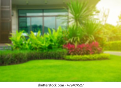 Modern House With Beautiful Landscaped Front Yard, Lawn And Garden Blur Background.Garden With Fresh Green Grass Both Shrub And Flower Front Lawn Background, Garden Landscape Design. 