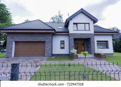 Modern House Exterior With The Garden And Brick Walls And Chain-link Fence