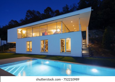Modern house, exterior in the night, lights on