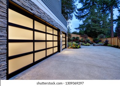 Modern House Exterior With Two Car Garage, Spacious Driveway At Twilight