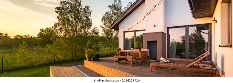 Modern house with patio and functional outdoor furniture, panorama