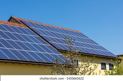 Modernes Haus mit fotovoltaischen Solarzellen auf dem Dach für alternative Energieerzeugung