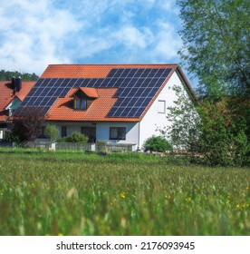 Modernes Haus mit Fotovoltaik-Solarzellen auf dem Dach für alternative Energieerzeugung