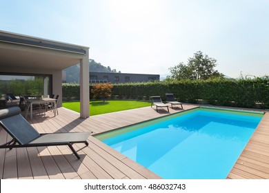 modern house with pool, loungers sun by the pool - Shutterstock ID 486032743