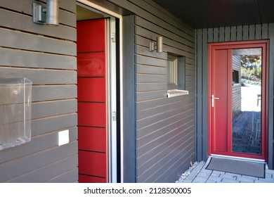 Modern house with wooden cladding and red door in summer sunny day, Austria, model house