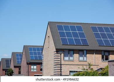 Modern houses with solar panels on the roof for alternative energy.