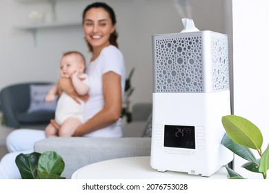 Modern Humidifier In Room With Mother And Her Baby