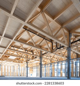 modern industrial hall with timber trusses and prefabricated concrete columns with many glass facade elements - Powered by Shutterstock