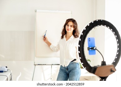 Modern Influencer Girl Blogger Recording Video Using Ring Lamp And Smartphone, Talking And Gesturing At Camera, Explain Something, Teaching Online Lesson Via Internet, Self Study And E-learning