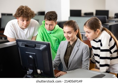 Modern Interested Teen Schoolchildren Learning Basics Of Programming With Friendly Female Teacher In Computer College..