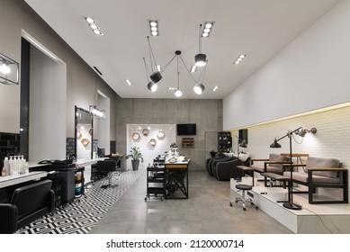 Modern Interior Of The Beauty Salon Which Consist Of Nail Salon And Barbershop With Black Lamps And Concrete Wall. Mirrors, Chairs, Backwashes And Other Equipment Are In The Salon.