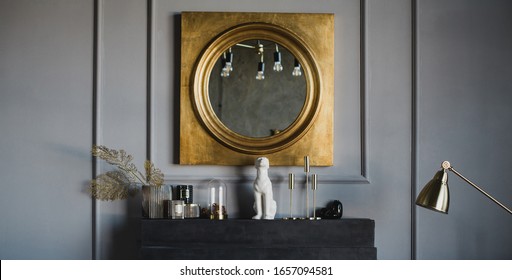 Modern Interior With Big Mirror In Golden Frame Hanging Above Black Decorative Fireplace.