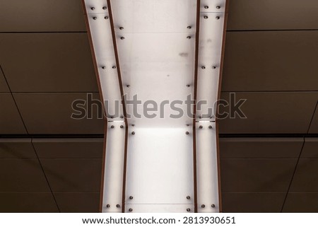 Modern interior ceiling with integrated white linear lighting and geometric brown panels