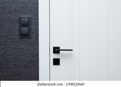 Modern interior design details - door, black switches and wallpaper