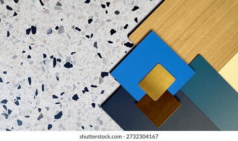 Modern Interior Design Material Mood Board Featuring White Terrazzo Stone, Light Oak Wood Texture, Blue and Teal Laminate Samples, and Brass Metallic Accents for Professional Architectural Decor.