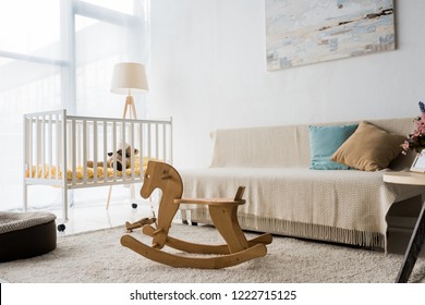 modern interior design of nursery room with crib and rocking horse chair