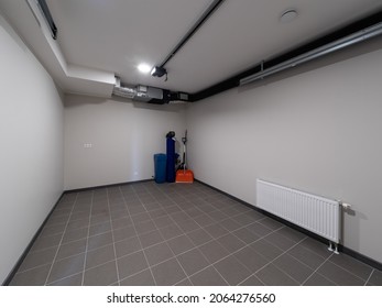 Modern Interior Of Garage Of Luxury Private House. Tile Floor. White Walls. No People.