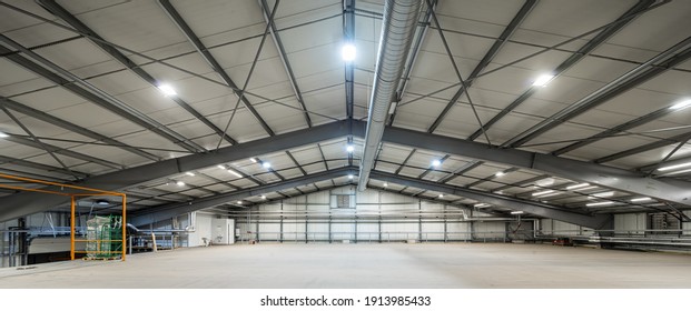 Modern interior of huge empty warehouse. New distribution storehouse. Metal construction. Industrial architecture.