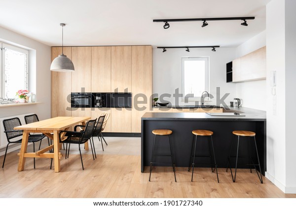 Modern interior of kitchen\
with kitchen island, granite kitchen island, wooden furnitureand\
stylish table and chairs. Spacious and luxurious space in\
apartment. 