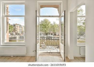 Modern interior with large open windows offering a scenic view of lush greenery and water, creating a warm and inviting atmosphere.