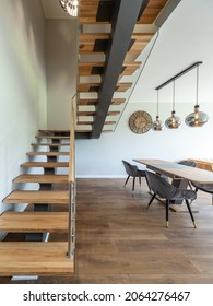 Modern Interior Of Luxury Apartment. Wooden Stairs. Spacious Living Room. Table And Chairs.