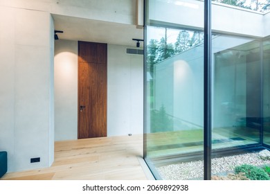 Modern interior of luxury private house. Stylish cottage. Glass wall. Wooden door.