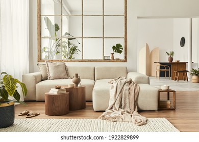 Modern interior of open space with design modular sofa, furniture, wooden coffee tables, plaid, pillows, tropical plants and elegant personal accessories in stylish home decor. Neutral living room. - Shutterstock ID 1922829899