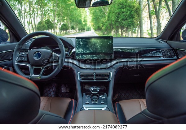 Modern interior shot of a  car.steering wheel,\
shift lever and multimedia\
screen.