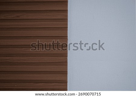 Modern interior wall background split into two textures: dark brown fluted wood paneling and a plain, light gray textured wallpaper